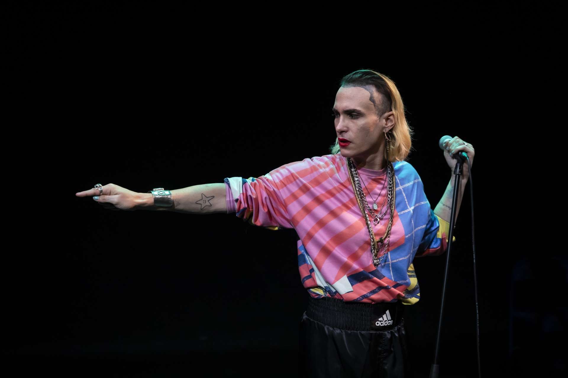 Laurene Marx debout de profil micro à la main bras droit tendu