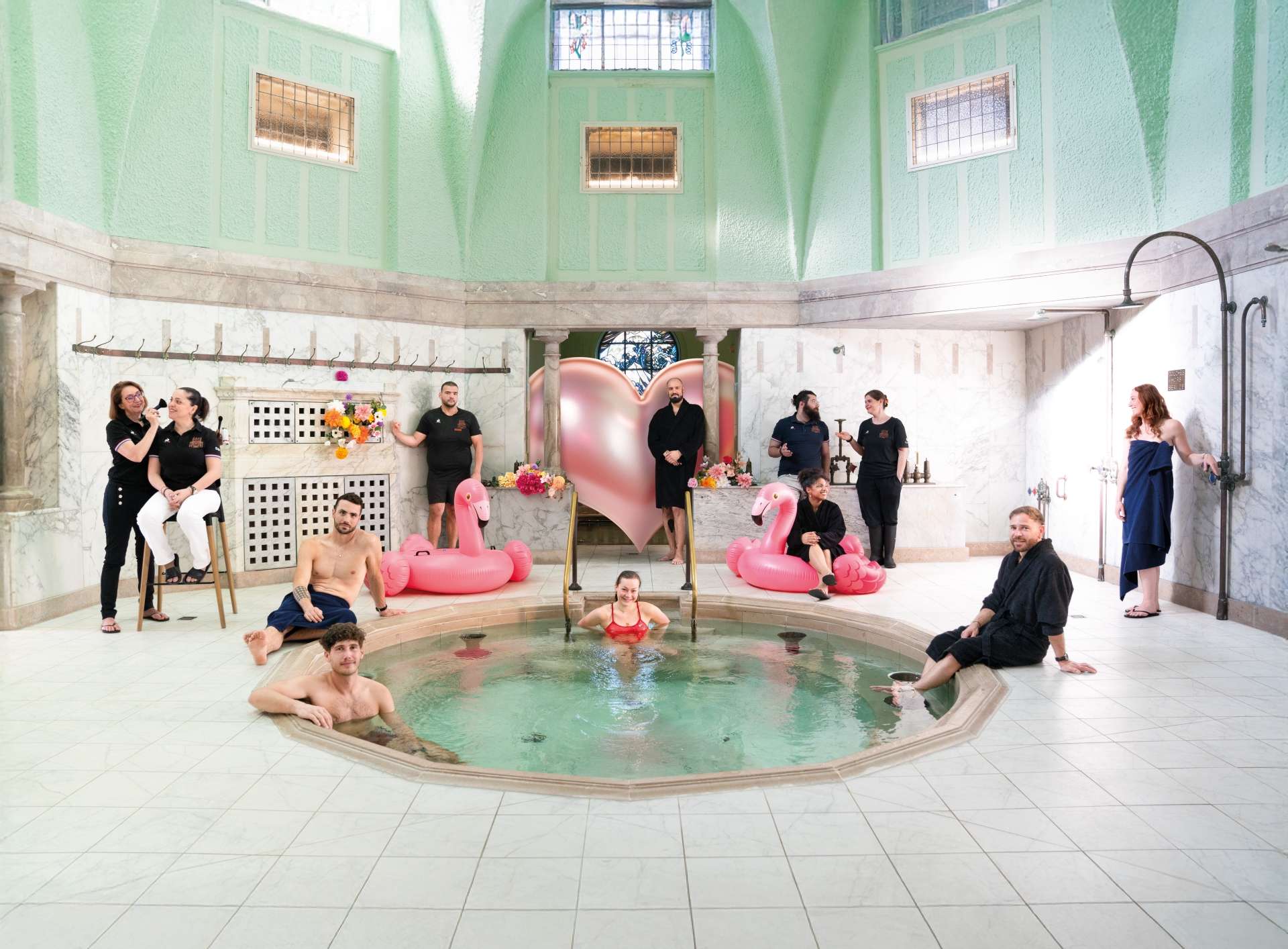 bains municipaux romains de strasbourg parti ancienne autour d'un bain chaud 11 personnes sont disposées tout autour maitre nageur, nageuse, estheticiennes, agents de nettoyage