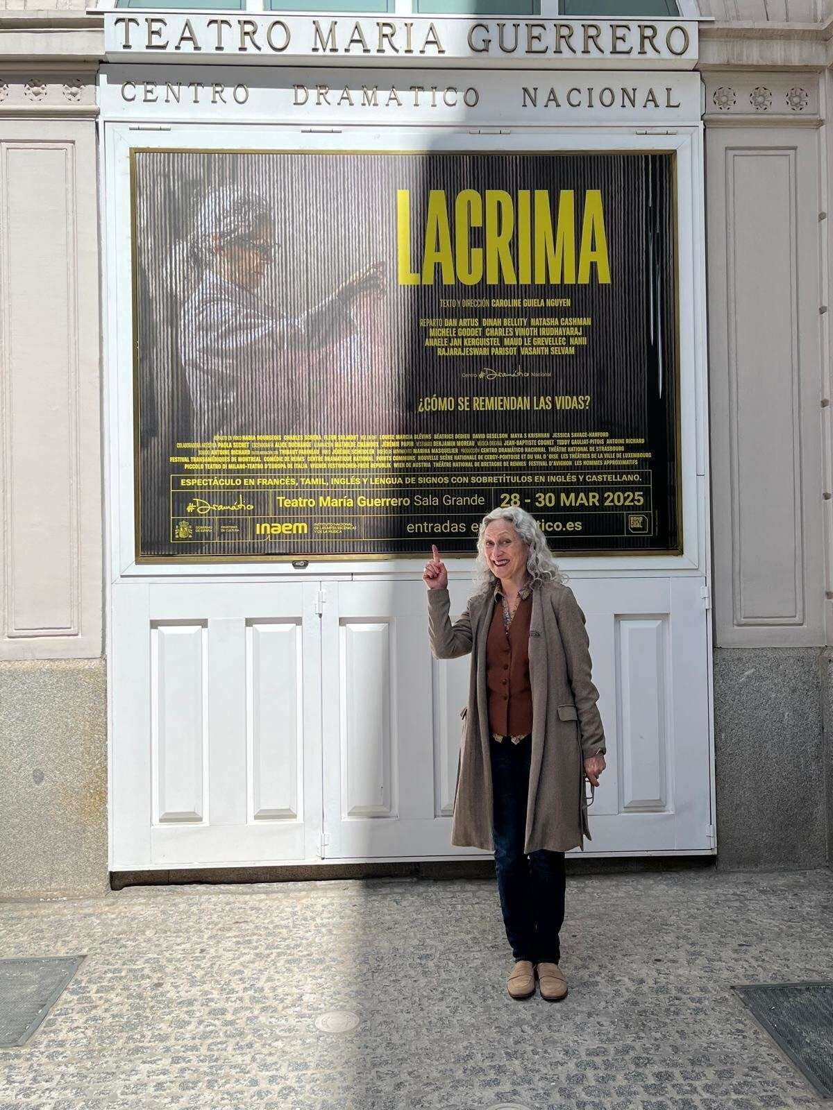 natasha cashman actrice debout devant l'affiche du spectacle sur la facade du theatre à Madrid tns on tour LACRIMA